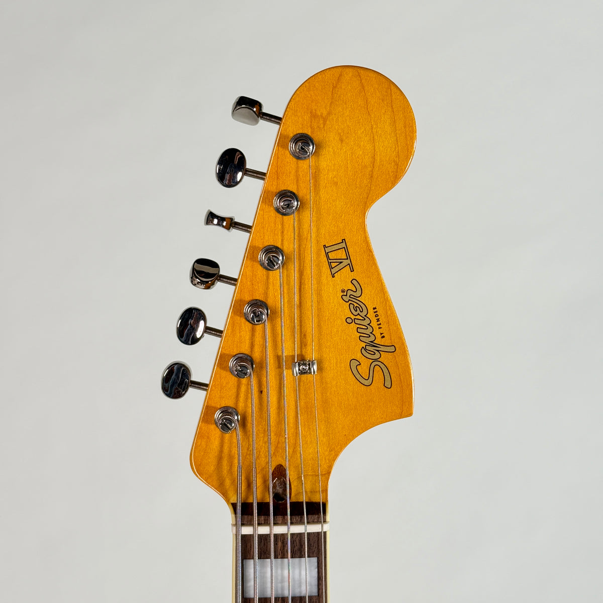 Used Squier Bass VI in black, front of the headstock