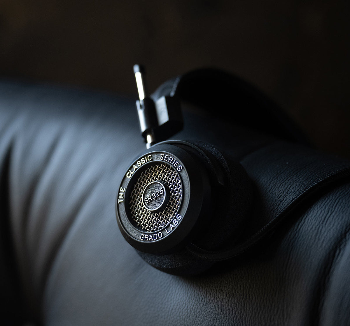 Grado SR325, close up of the earcup, resting on a black leather sofa