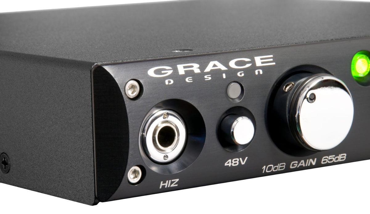 Close up of the front left corner of a Grace Design m101 preamp: the etched wordmark, the combo input, the 48V button, a green LED and the gain scale around the main knob