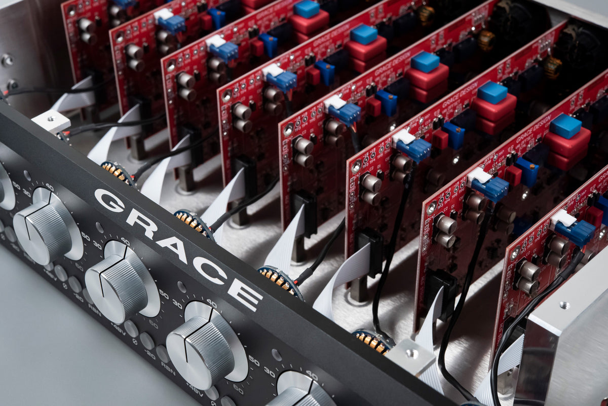 Inside a Grace Design m801 mk2 with the lid off: a row of eight red preamp circuit cards standing in the chassis behind the front panel