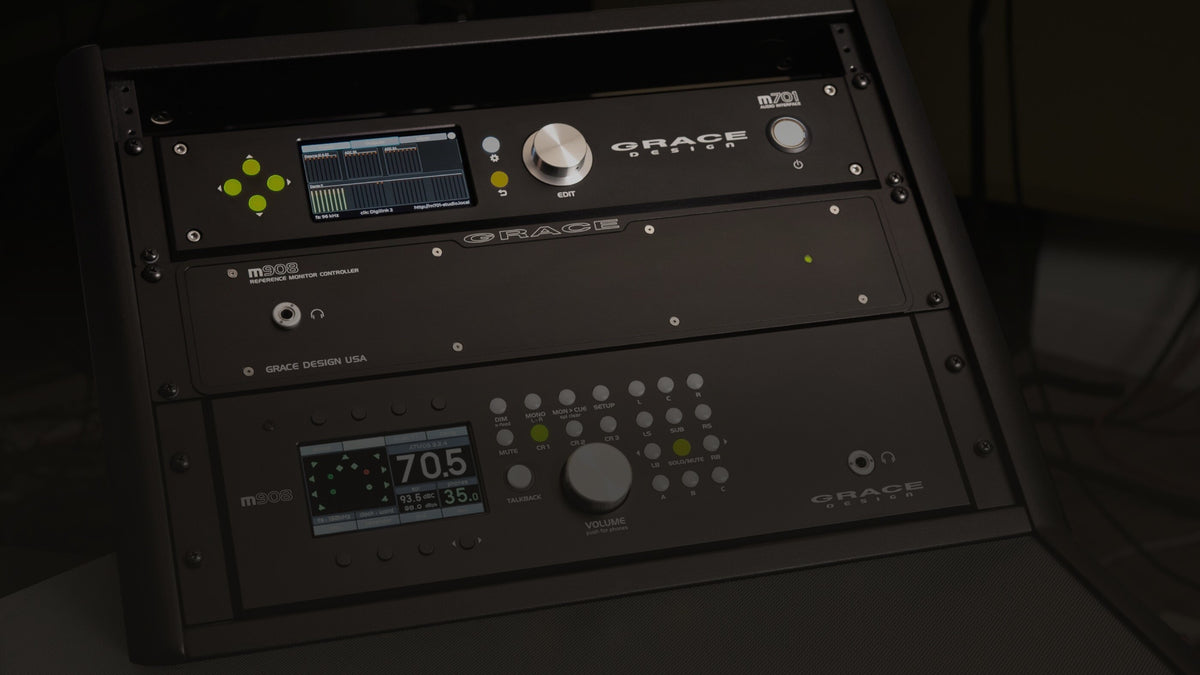 A Grace Design m908 monitor controller and its remote, with an m701 above them, fitted in a desktop studio rack