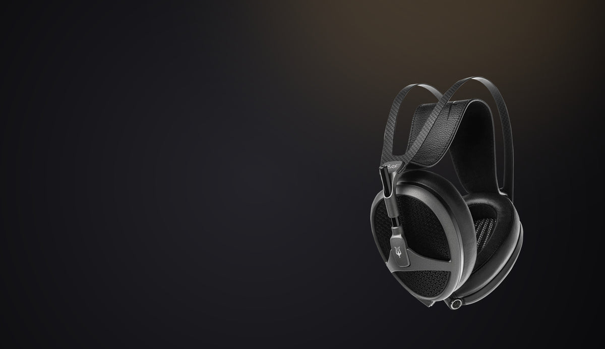 A pair of headphones lit against a dark ground
