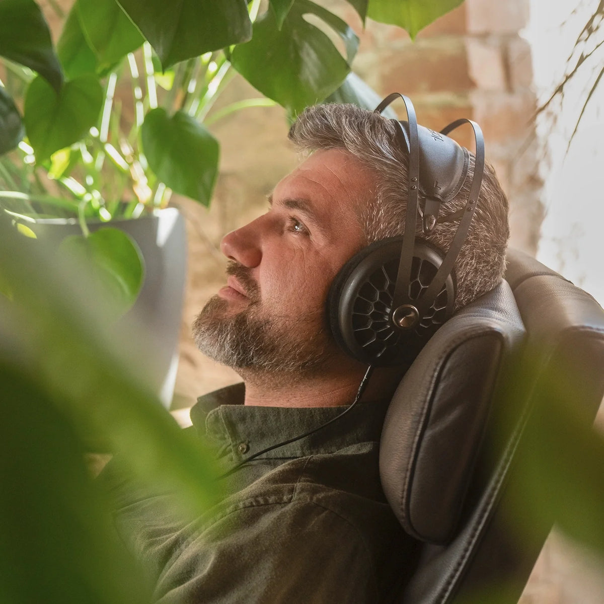 Meze Audio 105 AER, worn by a listener sitting in a chair