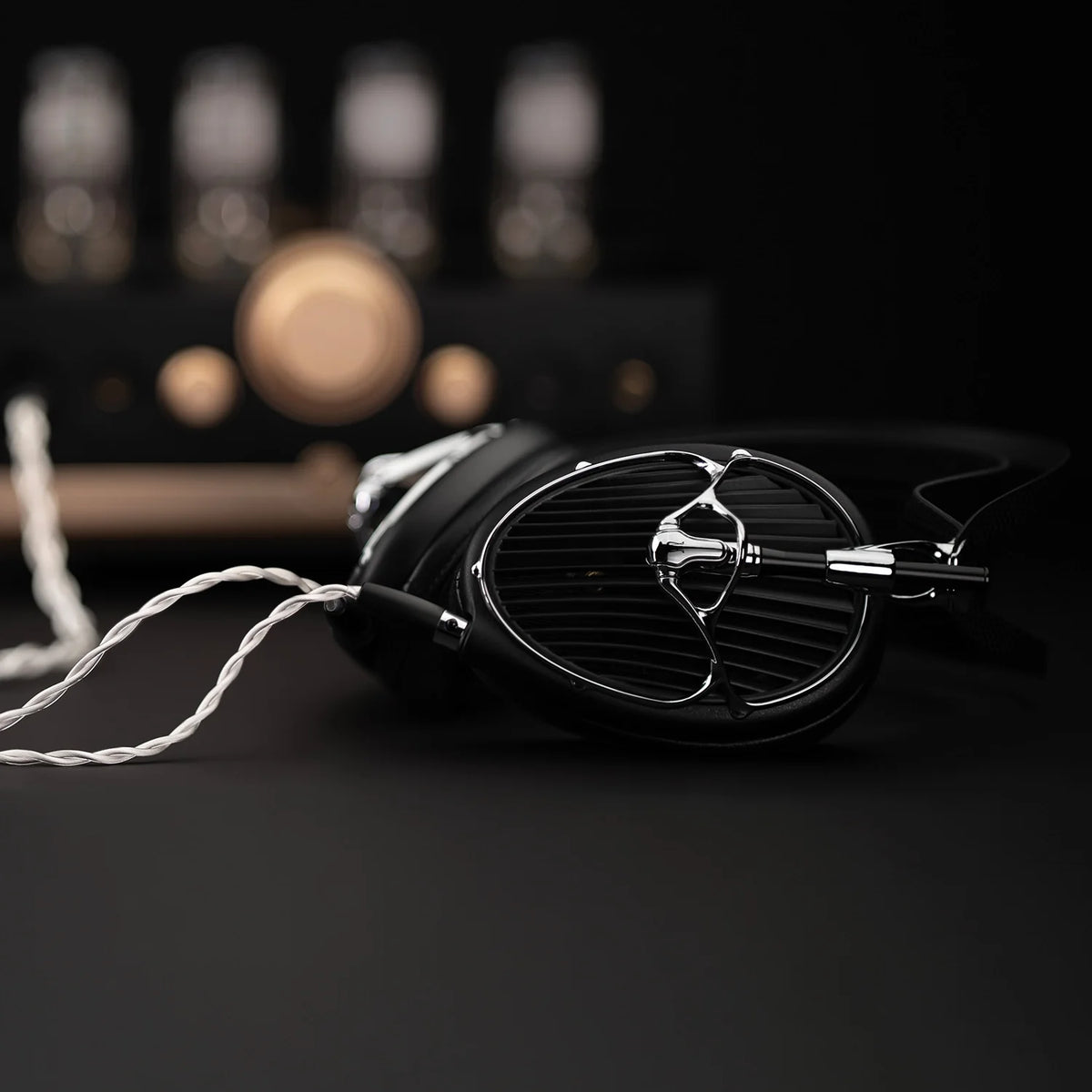 Meze Audio ARTA, lying on a desk in front of an amplifier
