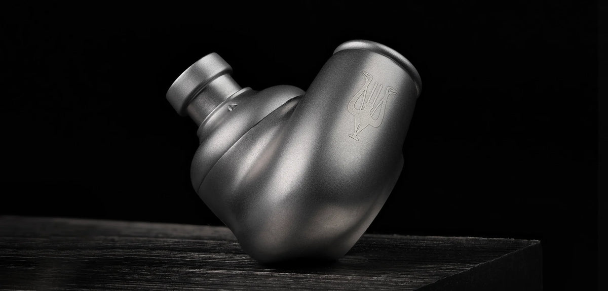Meze Audio ASTRU, an earpiece on a dark wood surface