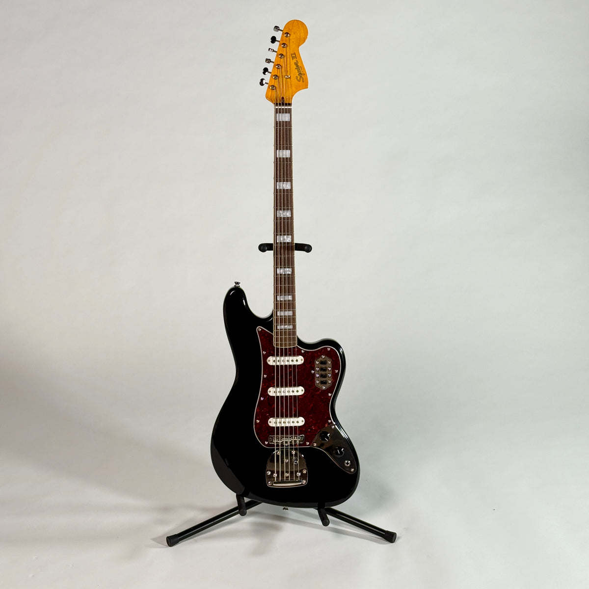 Used Squier Bass VI in black, full length, front, on a stand