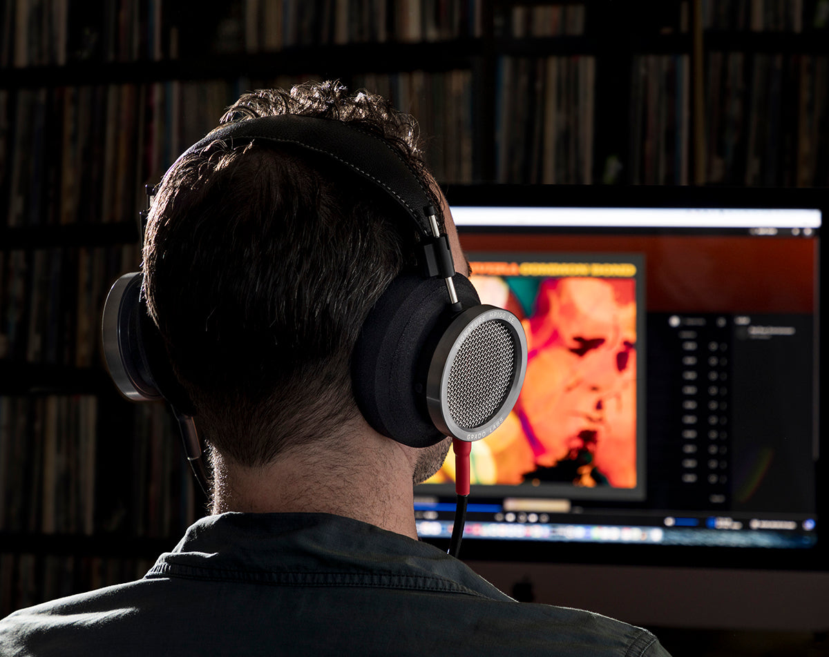 Grado Signature HP100 SE worn by a listener at a computer, seen from behind