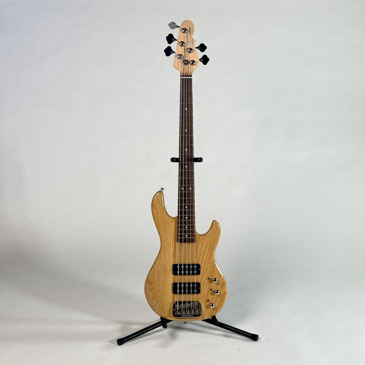Used G&L Tribute L-2500 five-string bass, natural, full length, front, on a stand
