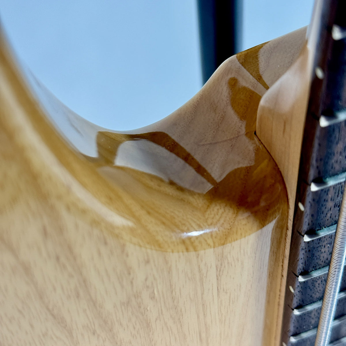 Used G&L Tribute L-2500 five-string bass, natural, close up of the finish at the upper horn
