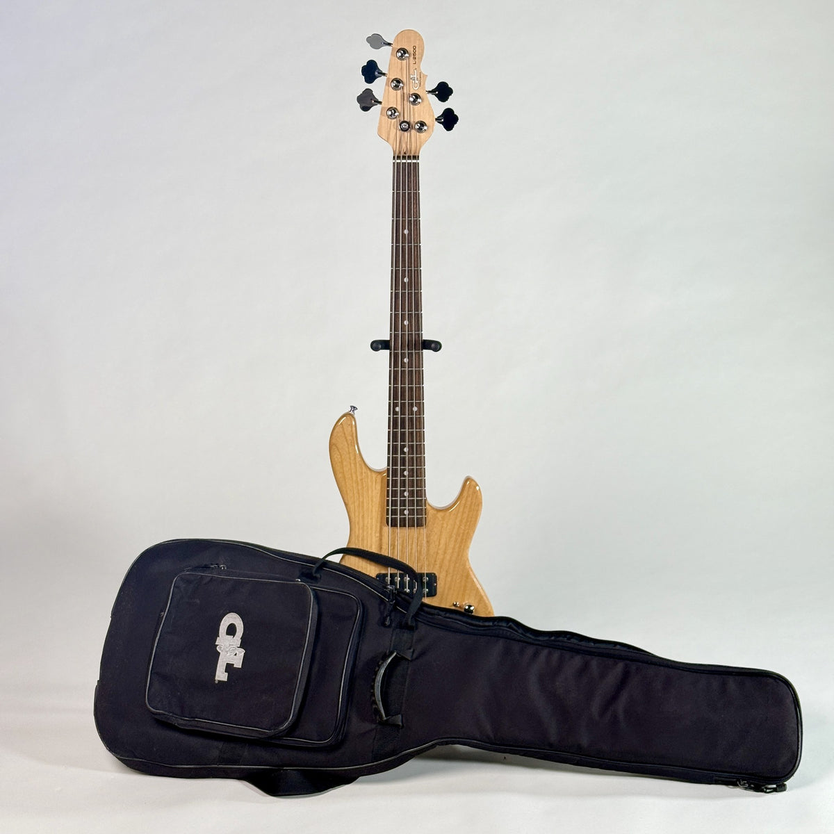 Used G&L Tribute L-2500 five-string bass, natural, and its G&L gig bag, from a little further back