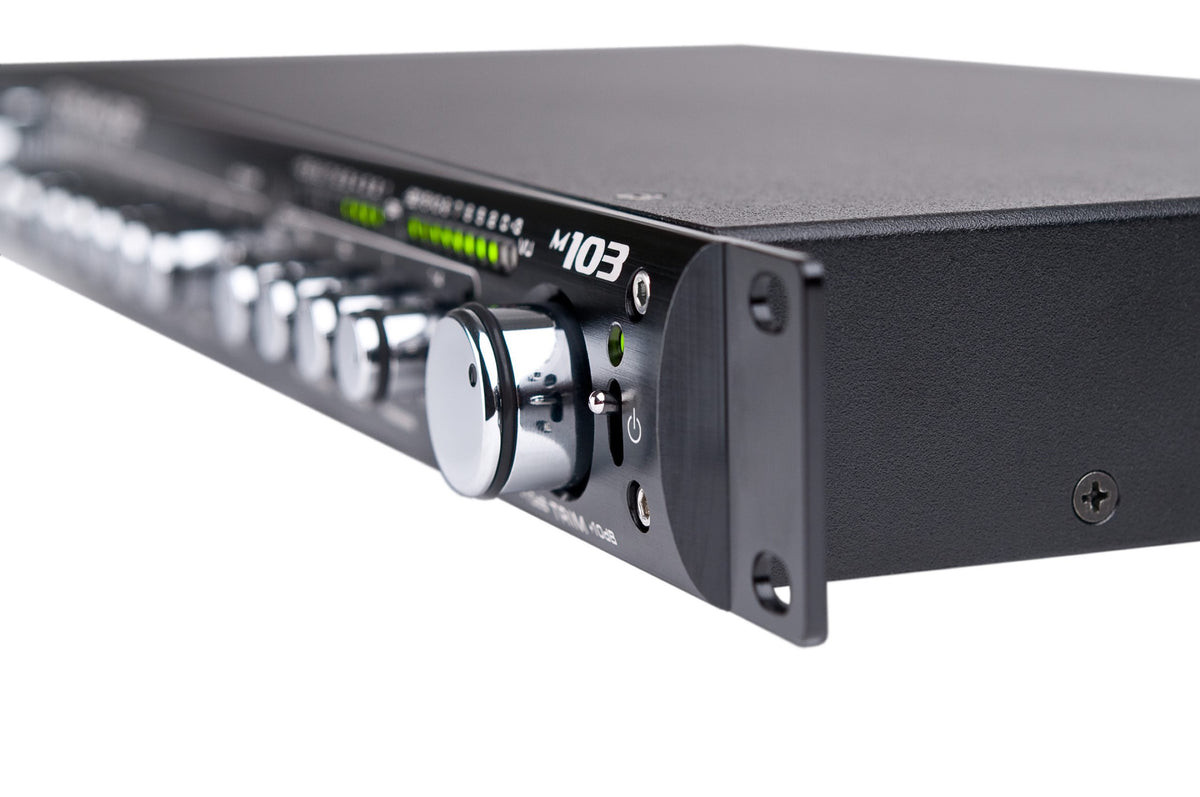 A Grace Design m103 seen from one end along its 1U front panel, the row of knobs and the LED meter running away into the distance