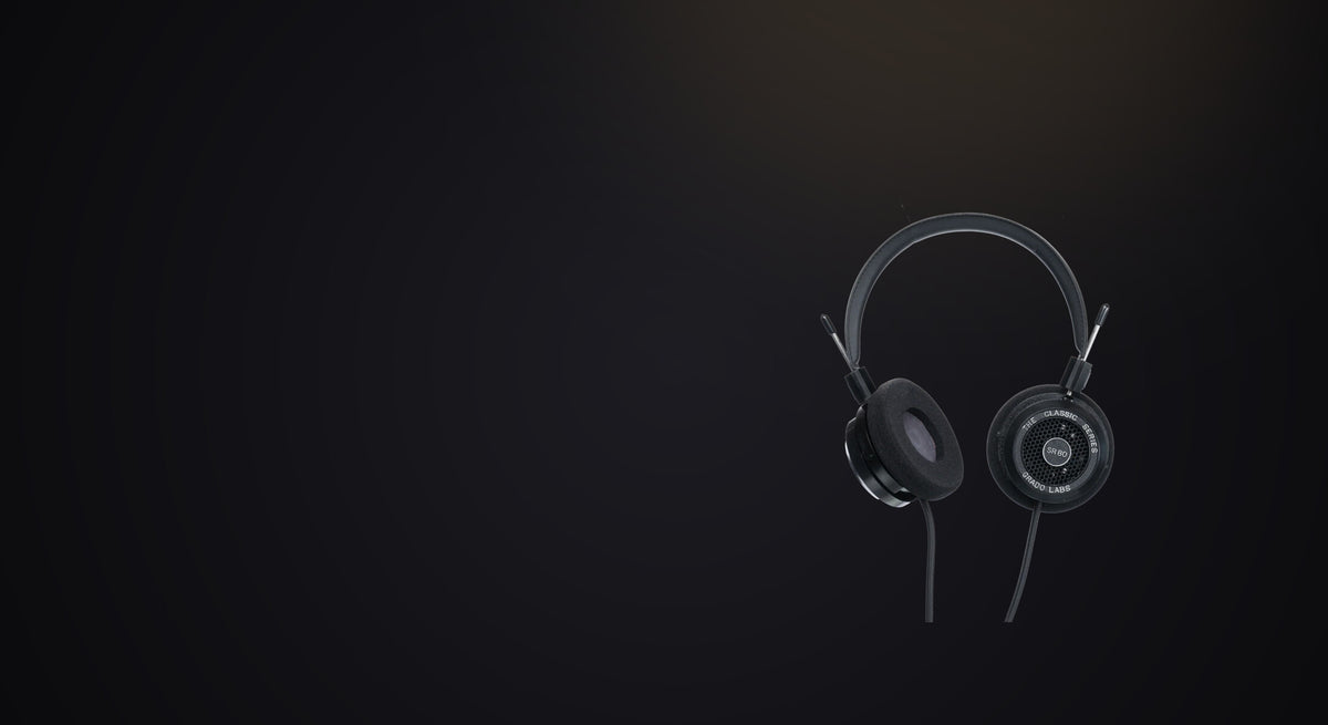 A single pair of headphones alone in a dark, almost empty room