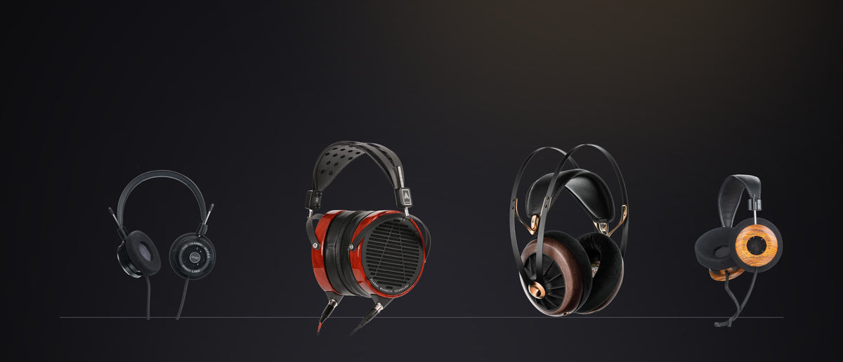 Four pairs of headphones standing on a shelf in a dark room