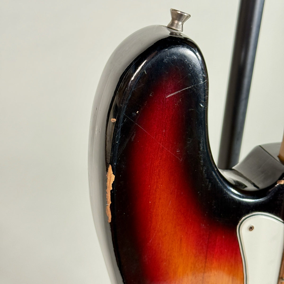Used unbranded P-bass style bass in sunburst, close up of chips on the upper horn