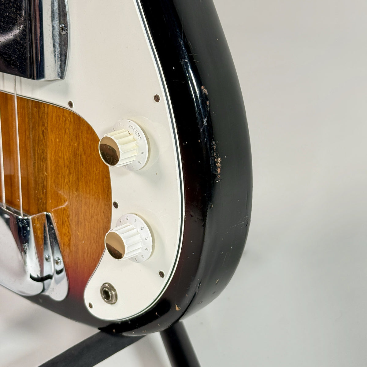 Used unbranded P-bass style bass in sunburst, close up of the controls and pickguard
