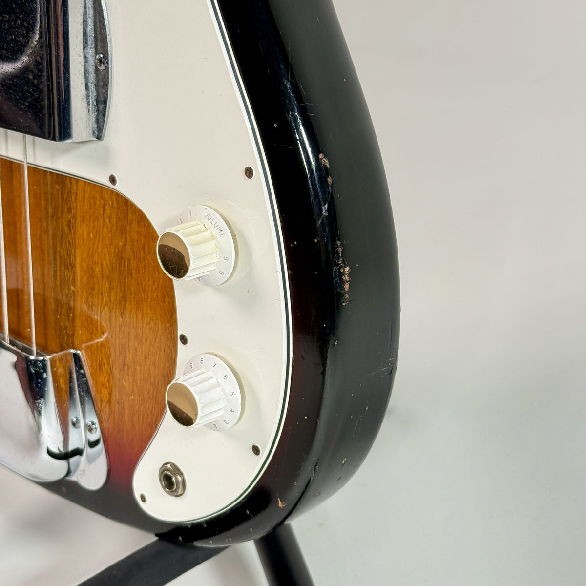 Used unbranded P-bass style bass in sunburst, second close up of the controls and pickguard