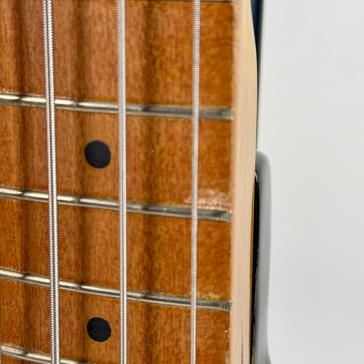 Used unbranded P-bass style bass in sunburst, close up of the fretboard and frets