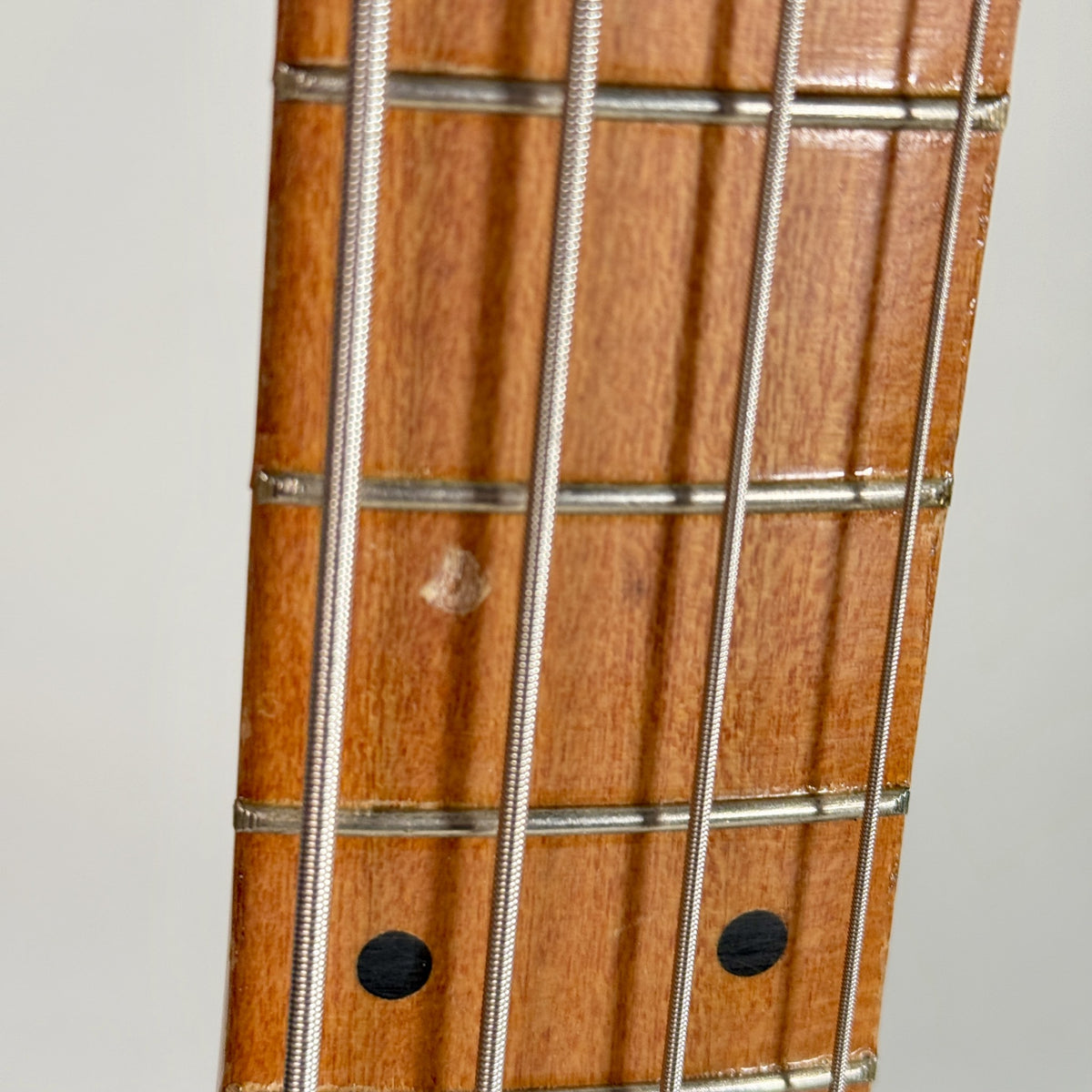 Used unbranded P-bass style bass in sunburst, close up of the fretboard, further up the neck
