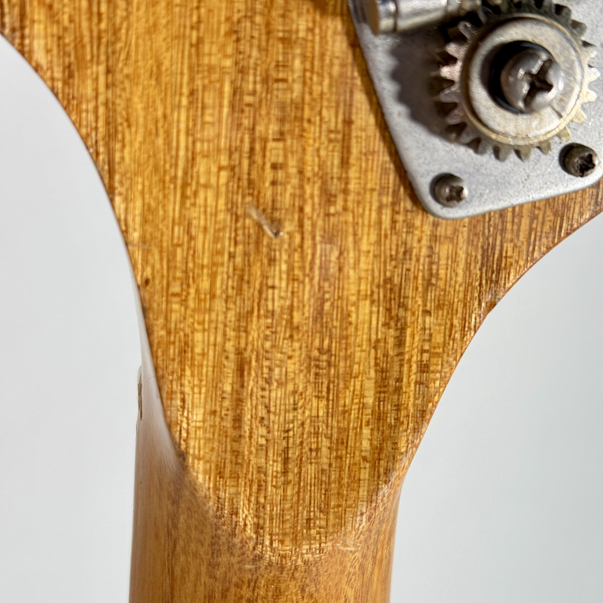 Used unbranded P-bass style bass in sunburst, close up of the back of the headstock